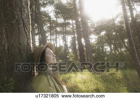 Woman relaxing against tree View Large Photo Image Stock Photography - Woman relaxing against tree. Fotosearch