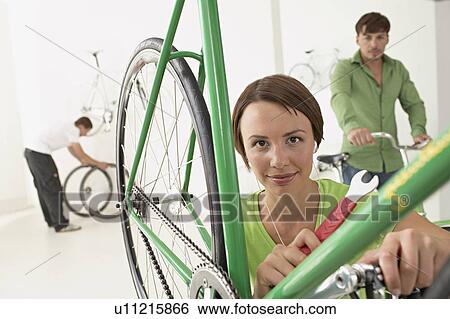 Stock Photograph - woman repairing bike. Fotosearch