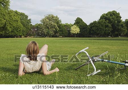 Stock Image - Woman resting in park. Fotosearch