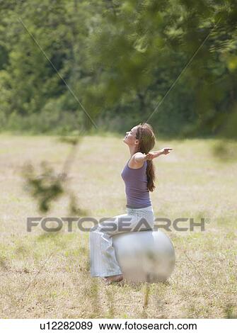 woman sat on yoga ball stretching View Large Photo Image Stock Photo - woman sat on yoga ball stretching. Fotosearch