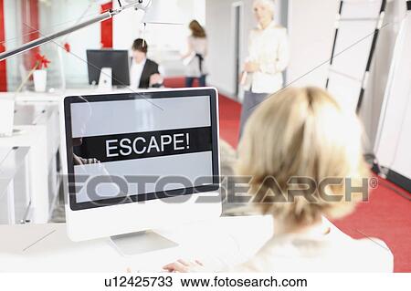 Stock Image - woman sitting on a desk and is working. Fotosearch