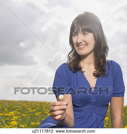 Stock Image - Woman sitting on meadow. Fotosearch