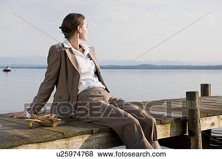 woman sitting on pier at lake View Large Photo Image Stock Photo - woman sitting on pier at lake. Fotosearch