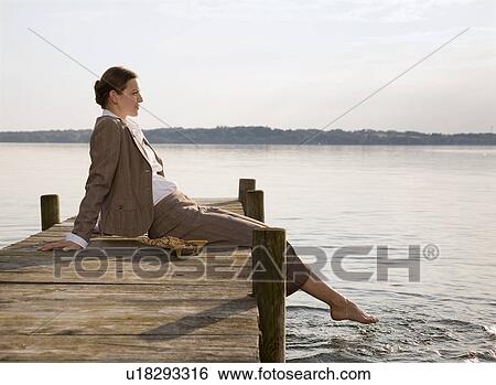 woman sitting on pier at lake View Large Photo Image Stock Photograph - woman sitting on pier at lake. Fotosearch