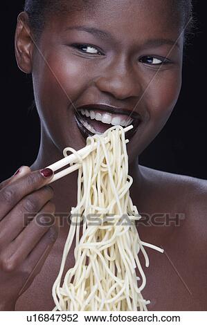 Woman smiling eating with chopsticks View Large Photo Image Stock Image - Woman smiling eating with chopsticks. Fotosearch