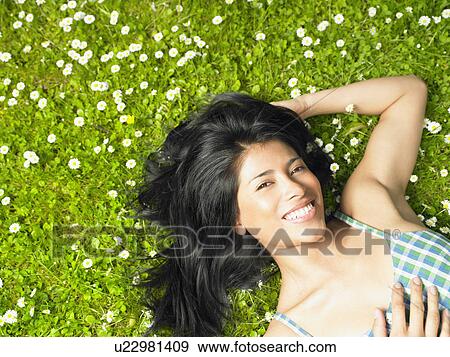 Stock Photo - Woman smiling, surrounded by daisies. Fotosearch