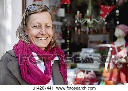 Stock Image - Woman standing before a window. Fotosearch