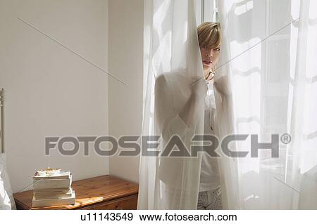 Woman standing behind curtain View Large Photo Image Stock Photo - Woman standing behind curtain. Fotosearch