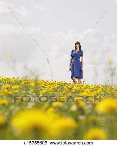 Woman standing on meadow View Large Photo Image Stock Photograph - Woman standing on meadow. Fotosearch