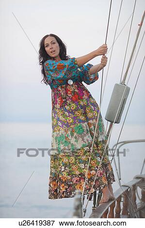 Stock Photo - woman swinging between ropes of a boat. Fotosearch