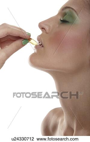 Stock Image - Woman taking vitamin pill. Fotosearch
