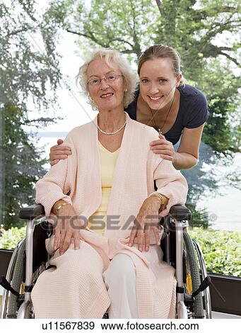 Stock Photo - woman touching senior woman's shoulders. Fotosearch