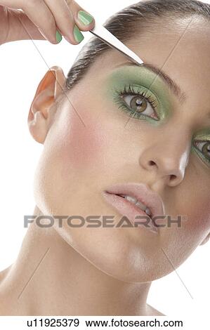 Woman tweezing her eyebrows View Large Photo Image Stock Photo - Woman tweezing her eyebrows. Fotosearch