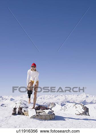 Stock Photograph - woman undressing on mountain top. Fotosearch