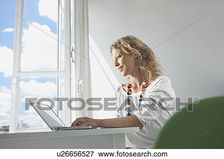 Stock Photo - woman using computer at home. Fotosearch