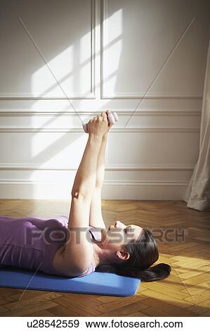Stock Photo - Woman using weights. Pilates.. Fotosearch