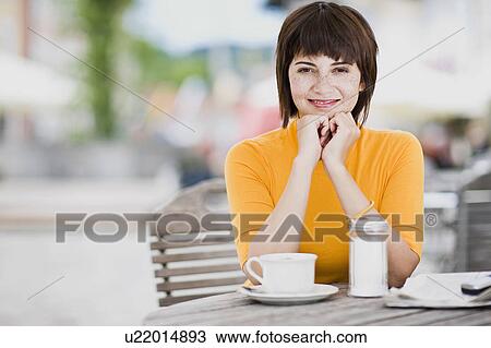 Stock Image - woman waiting in a street cafe. Fotosearch
