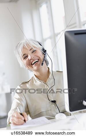 woman with a headset works in an office View Large Photo Image Stock Photo - woman with a headset works in an office. Fotosearch