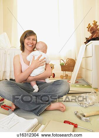 Picture - Woman with baby building furniture. Fotosearch