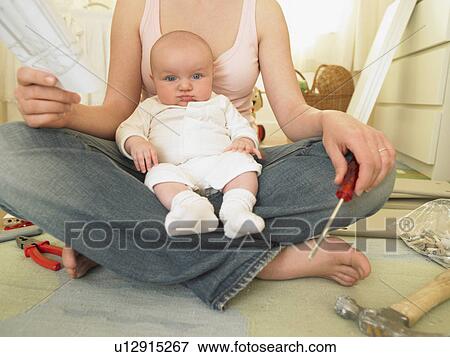 Woman with baby building furniture View Large Photo Image Stock Photo - Woman with baby building furniture. Fotosearch