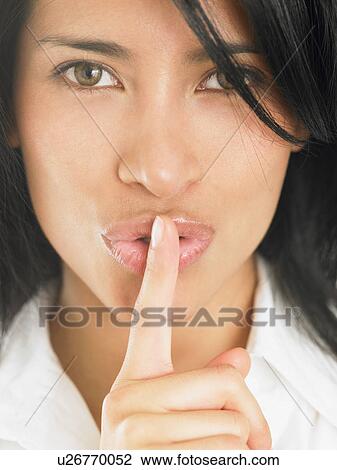 Stock Image - Woman with finger over her mouth. Fotosearch