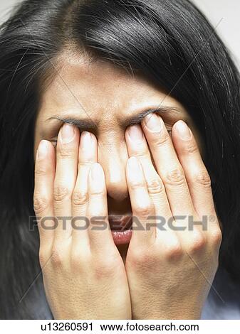 Stock Image - Woman with her hands on her face. Fotosearch