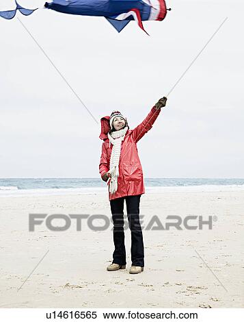 Stock Photography - Woman with kite on beach. Fotosearch