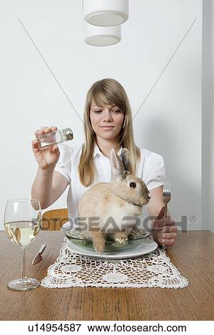 Stock Photo - Woman with living rabbit on her plate. Fotosearch