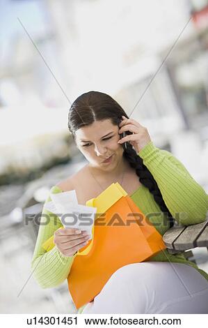 Stock Image - woman with shoppingbag and receipt. Fotosearch
