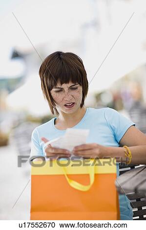 Stock Image - woman with shoppingbag and receipt. Fotosearch