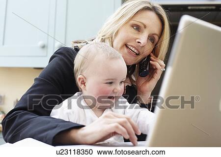 Stock Image - woman working with a baby. Fotosearch