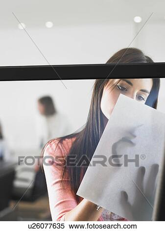 Stock Photography - woman writing against window. Fotosearch
