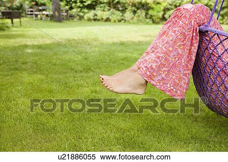 Stock Photography - woman's feet hanging out of a swing. Fotosearch