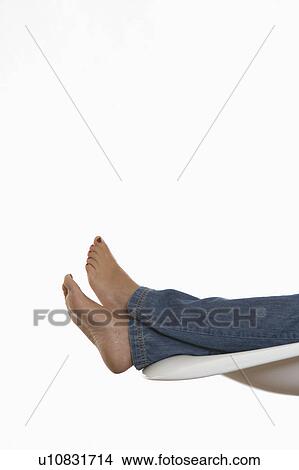 Picture - woman's legs relaxed on a chair. Fotosearch