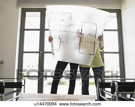 Picture - women looking at blueprint. Fotosearch
