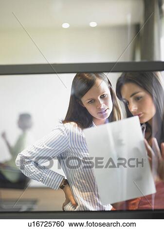 Stock Image - women writing against window. Fotosearch