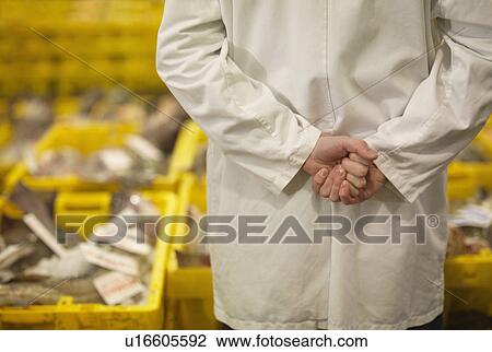Stock Image - Worker And Crates Of Fish In Market. Fotosearch
