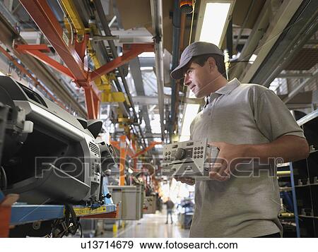 Stock Photo - Worker Assembling Car In Plant. Fotosearch