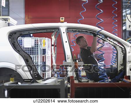 Picture - Worker Assembling Car On Production Line. Fotosearch