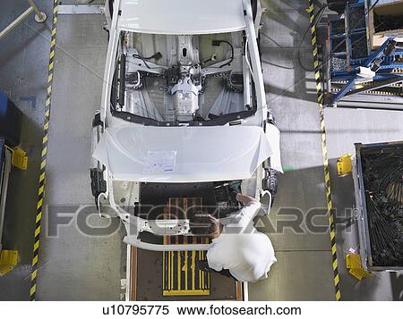 Stock Photography - Worker Assembling Car On Production Line. Fotosearch