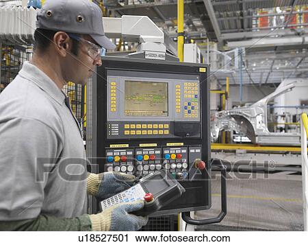 Stock Image - Worker At Controls In Car Plant. Fotosearch