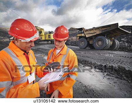 Stock Image - Workers In Mine Inspecting Coal. Fotosearch