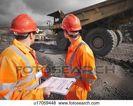 Stock Photo - Workers Inspecting Trucks In Coal Mine. Fotosearch