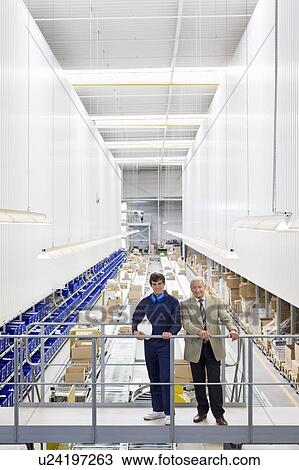 Stock Image - workman and boss in storage. Fotosearch
