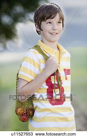 young boy carrying a net of fruit View Large Photo Image Stock Image - young boy carrying a net of fruit. Fotosearch