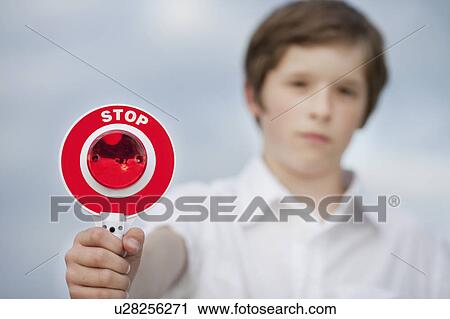 Stock Image - young boy holding up stop sign. Fotosearch
