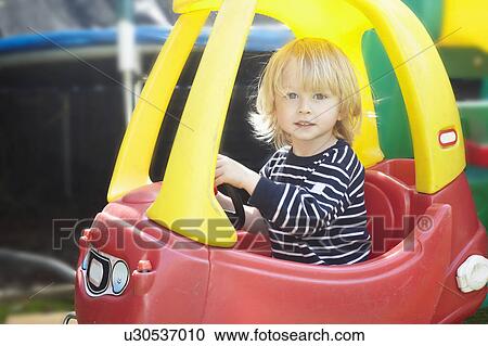 Young boy in a toy car View Large Photo Image Stock Image - Young boy in a toy car. Fotosearch