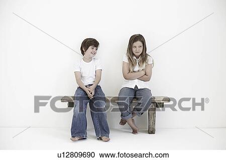 Stock Image - Young boy smiling at shy young girl. Fotosearch