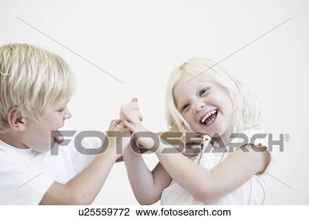 Stock Image - Young boy tickling young girl. Fotosearch