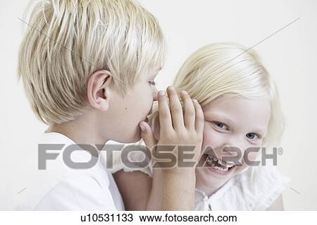 Young boy whispering into girl's ear View Large Photo Image Stock Image - Young boy whispering into girl's ear. Fotosearch